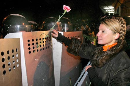 Yulia Tymosjenko, medlem av nasjonalforsamlingen og en av Justsjenkos viktigste allierte, markerer sine fredelige hensikter overfor opprørspolitiet. (Foto: Reuters)