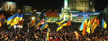 Jusjtsjenkos tilhengere vifter med flagg og opposisjonens farger i Kiev søndag kveld. (Foto: S.Supinsky, AFP)