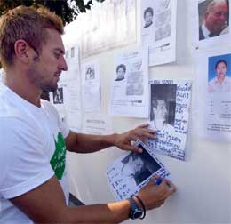 Slekt og venner søker etter savnede. Her henger briten Luke Simon opp bilde av sin savnede bror. (Foto: AFP/Scanpix)