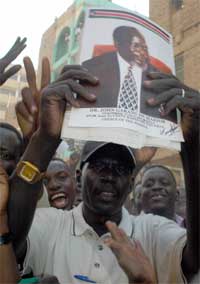 FEIRER: En sør-sudans mann feirer fredsavtalen med bildene av SPLM/A leder John Garang i hendene. Foto: AFP/Scanpix. 