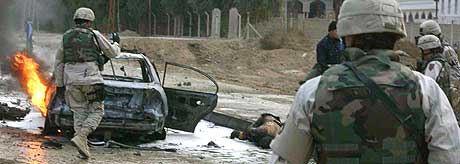 NOK EN BILBOMBE: Stadige terrorhandlinger tyder på at valget i Irak vil bli utsatt. Her rydder amerikanske soldater er område i byen Baquba, etter at en bombe eksploderte 5. januar 2005. Minst seks personer ble drept. (Foto: Ali Yussef/AFP)