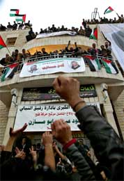 Tilhengerne hilser Abbas som hever armene på balkongen med bilder av ham selv og Arafat (Scanpix/AP)