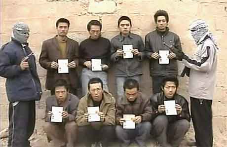 Dette bildet, som ble lagt ut på en internettside 18 januar 2005, viser to gisseltakere på hver sin side av de åtte bortførte kineserne. (FOTO: AFP)