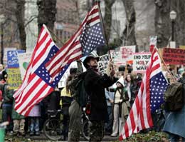Mange er skeptiske til nye år med Bush. Her holder demonstranter i Portland flagget opp-ned (Scanpix/AP)