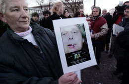 MARKERING: En nederlandsk kvinne holder opp bildet av den drepte filmskaperen Theo van Gogh utenfor lokalene der de innledende rettsmøtene startet i dag. (Foto: AFP)