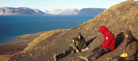 Noen fossiljegere setter seg for å studere kartet(Foto: Roger Myren/NRK)