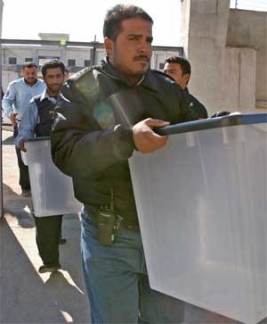Irakisk politi frakter boksene som stemmesedelene skal puttes i. (Foto: Scanpix / Reuters / Atef Hassan)
