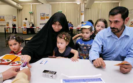 En irakisk kvinne har tatt med seg familien til et valglokale i Melbourne i Australia. (Foto: AFP/Scanpix)