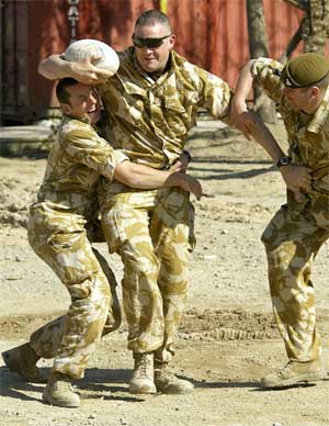 Britiske soldater lader opp foran valget med en rugbykamp ved Saddam Husseins palass i Basra. (Foto: Scanpix / AP / Odd Andersen)