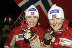 En glad verdensmester Marit Bjørgen (t.v.) og bronsevinner Hilde Gjermundshaug Pedersen med VM-medaljene etter sprinten i Val di Fiemme. (Foto: Terje Bendiksby / SCANPIX)