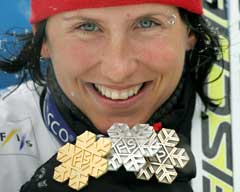 Marit Bjørgen viser frem sine tre VM-medaljer. (Foto: AFP/Scanpix)