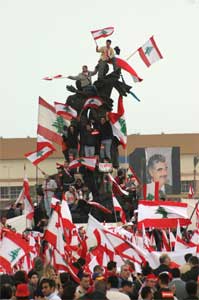 Demonstranter med flagg klatret opp på Martyrstautuen (Scanpix/Reuters)
