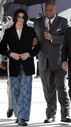 Michael Jackson ankommer rettslokalene i Santa Barbara torsdag, kun iført pyjamas og dressjakke. Foto: Kimberly White, AFP Photo.