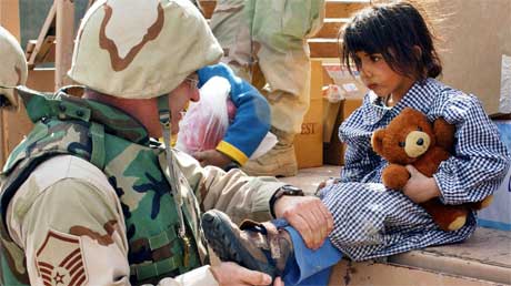 En amerikansk soldat gir nye sko til en irakisk beduinjente. (Foto: Scanpix / Reuters)