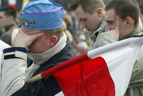 Paven hadde ei svært sterk stilling i Polen. Her sørgjer ein ung mann i Krakow. (Foto: AP/Scanpix)