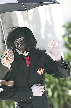 Michael Jackson blir tatt av vinden på vei til rettslokalene onsdag 13. april. Foto: Scanpix.