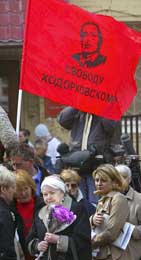 Et rødt flagg - men med bilde av Khodorkovskij, og i midten hans mor, Marina (Scanpix/AP)
