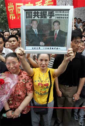 En kinesisk kvinne viser fram det historiske bildet av Kuomintang-lederen Lien Chans møte med Kinas president Hu Jintao. (Foto: AP/Scanpix)