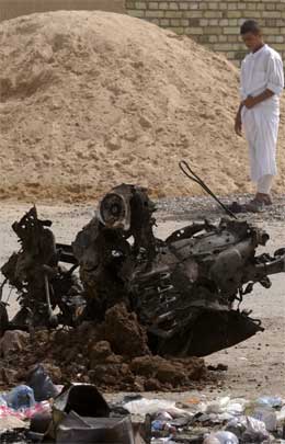 Ein irakisk mann ser på restane av bilen ein sjølvmordsaksjonist sprengde i lufta i Bagdad i dag. Minst fire menneske vart drepne. (Foto: AP/Scanpix)