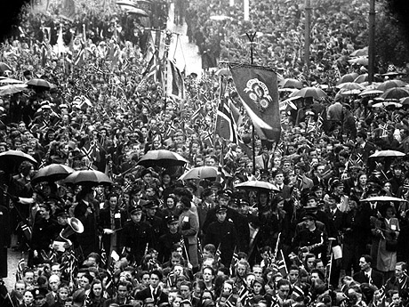 Øsende regn la ingen demper på festelighetene under den første feiringen av nasjonaldagen etter krigen. Bildet er fra Oslo 17. mai 1945. Foto: NTB / Scanpix