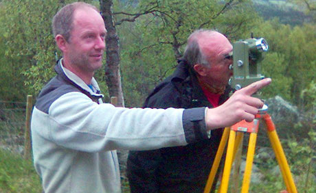 Jon Kvam (t.v) og geolog Erik Sloreby i Statens Vegvesen studerer steinblokka oppe i fjellsida.