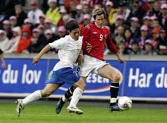 Morten Gamst Pedersen i aksjon mot Italias Mauro G. Camoranesi. (Foto: Tor Richardsen / SCANPIX) Morten Gamst Pedersen i aksjon mot Italias Mauro G. Camoranesi. (Foto: Tor Richardsen / SCANPIX)