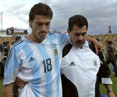 Argentinas Christian Gonzalez fikk trøst av assistenttreneren etter tapet mot Ecuador. (Foto: AP/Scanpix)