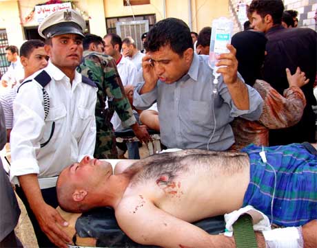 FÅR HJELP: En såret mann er blitt fraktet til sykehuset i byen, hvor det en stund var kaotiske tilstander. Foto: Reuters/Scanpix.