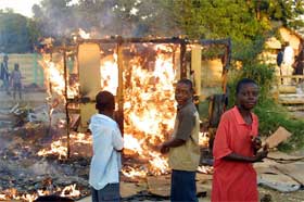Barn i Harare-forstaden Glen View ser en bod brenne ned etter myndighetenes aksjon. (Foto: AFP/Scanpix)