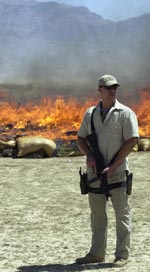 En bevæpnet soldat passer på bålet med 30 tonn afghansk narkotika. (Foto: AFP) En bevæpnet soldat passer på bålet med 30 tonn afghansk narkotika. (Foto: AFP)