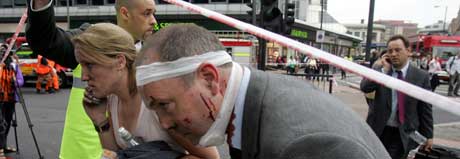 En skadd T-banepassasjer blir hjulpet ut av Edgware Road-stasjonen. Foto: AP/Scanpix