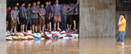 Ansatte i et varhus i Fuzhou har barrikadert seg mot flommen fra "Haitang". (Foto: AP)