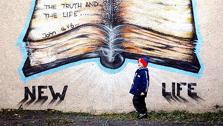 En liten gutt går hjem fra skolen og forbi et veggmaleri med teksten "Nytt liv" vest i Belfast. Foto: AFP/Scanpix En liten gutt går hjem fra skolen og forbi et veggmaleri med teksten "Nytt liv" vest i Belfast. Foto: AFP/Scanpix