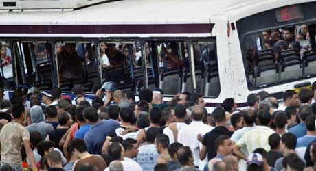En stor flokk arabere omringet bussen, og noen kastet også stein og flasker mot den (Scanpix/Reuters) En stor flokk arabere omringet bussen, og noen kastet også stein og flasker mot den (Scanpix/Reuters)
