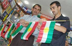 Noen menn gjør klar bannere med kurdiske flagg til åpningen av den kurdiske nasjonalforsamlingen. (Foto: Scanpix/AFP. S. Hamed)