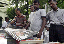 Innbyggerne i Colombo leser om drapet på utenriksminister Lakshman Kadirgamar. Foto: AP/Scanpix