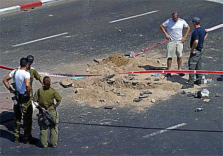 Israelske soldater inspiserer krateret etter en av rakettene som ble skutt mot Eilat.(Foto:AFP/Scanpix)