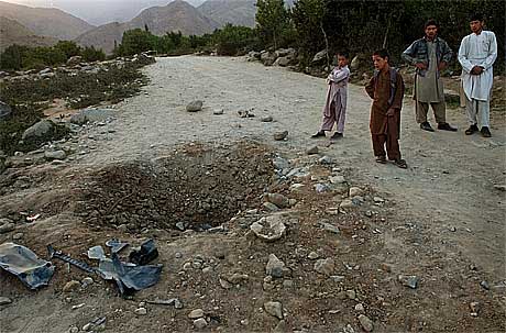 Afghanistan er en eneste stor krigskirkegård. To afghanske gutter betrakter et krater etter en rakett.(Foto:AP/Scanpix)