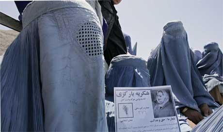 Afghansk kvinne med pamflett for en kvinnelig valgkandidat (Scanpix/Reuters)