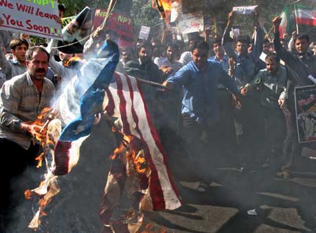Under de kraftige protestene brente demonstrantene det amerikanske og franske flagget (Scanpix/AP)