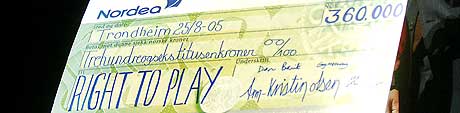 Kronprinsen deler ut en sjekk på 360 000 kroner fra Kronprinsparets humanitære fond til Right to Play- aksjonen, her representert av Johann Olav Koss i Trondheim i dag. (Foto: Scanpix)