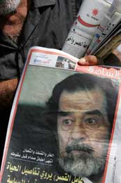 Avisselger med bilde av Saddam, som blir stilt for retten 19.oktober (Scanpix/AFP)
