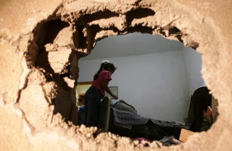En palestinsk jente leter i ruinene av et ødelagt hus i Beit Lahya lørdag morgen. (Foto: M.Abed, AFP) En palestinsk jente leter i ruinene av et ødelagt hus i Beit Lahya lørdag morgen. (Foto: M.Abed, AFP)