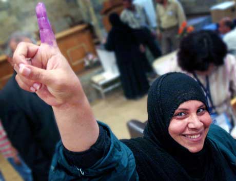 En kvinne på et sykehus i Bagdad har nettopp stemt og viser stolt en finger med blekk. Ved sykehusene er valget allerede i gang (Scanpix/Reuters)
