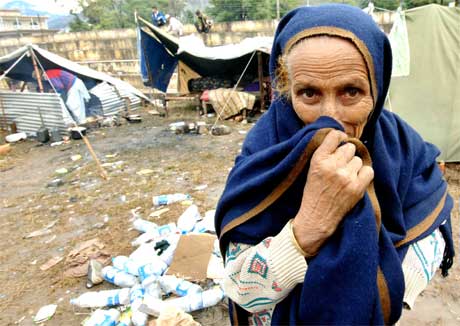 Ei eldre kvinne dekkjer til nasa for å sleppe lukta som ligg over denne provisoriske flyktningleiren. (Foto: AFP/Scanpix)