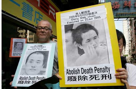 Demonstranter mot dødsstraff bærer plakater med bilder av narkotikaselgere i Hongkong som er henrettet på fastlandet (Scanpix/Reuters) 