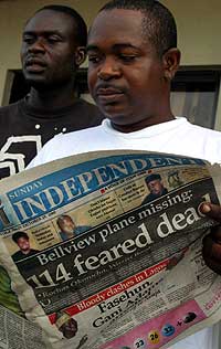 En nigerianer leser om flyulykken i dagens avis. (Foto: AP/Scanpix)