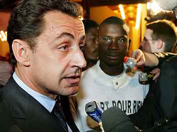 Innenriksminister Nicolas Sarkozy snakker til pressen. Ved siden av Ahmad, en representant for ungdommene. Foto: Joel Saget, AFP