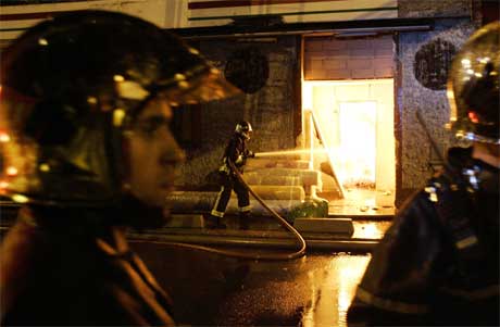 Brannmannskaper slukker en brann i et hus i Aubervilliers, nord for Paris i natt. (Foto: Scanpix / AP)