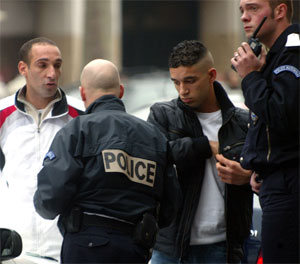 Politimenn sjekker identitetspapirer til to forbipasserende ved Champs Elysees. (Foto; Mehdi Taamallah/AP/Scanpix) 